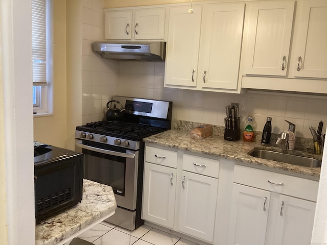 kitchen with white cabinetry, sink, decorative backsplash, light tile patterned floors, and stainless steel range with gas stovetop