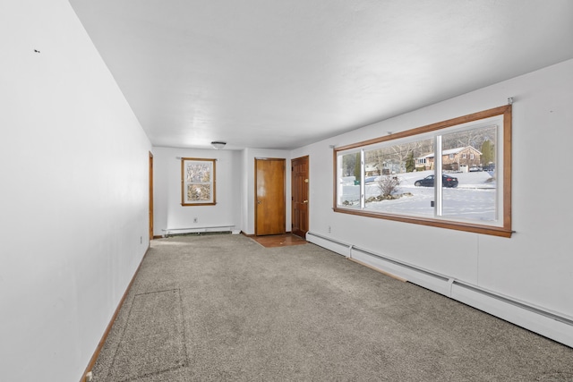 carpeted spare room with a baseboard heating unit