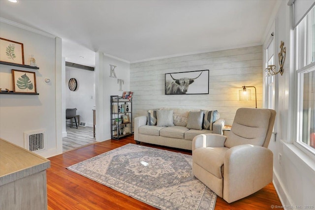 living room with crown molding, wood-type flooring, and wood walls