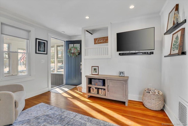 foyer entrance featuring hardwood / wood-style floors and crown molding