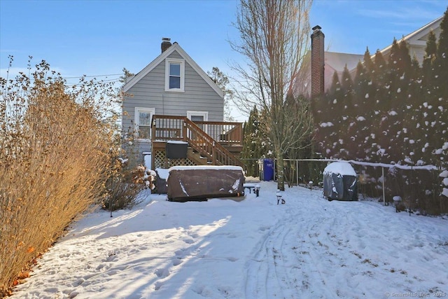 snow covered property with a wooden deck