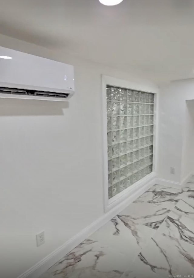 unfurnished room featuring a wall unit AC