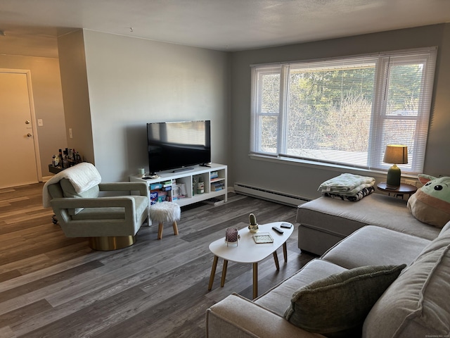 living room with a baseboard heating unit, a wealth of natural light, and dark hardwood / wood-style floors