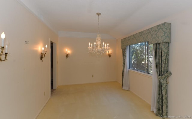 spare room featuring an inviting chandelier and vaulted ceiling