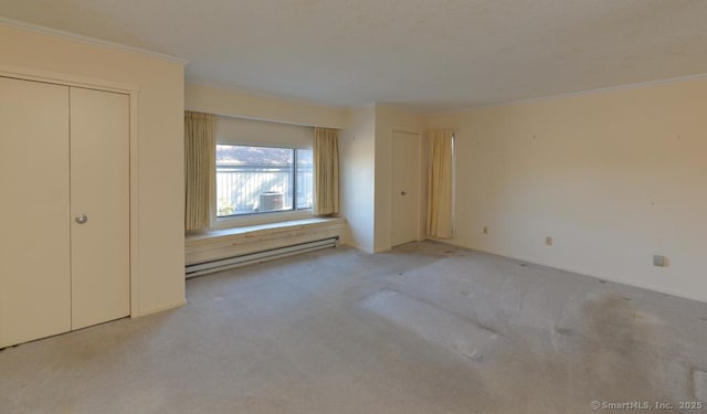 unfurnished bedroom featuring crown molding, light colored carpet, and baseboard heating