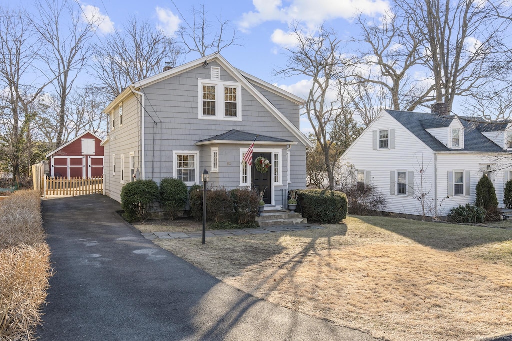 view of front of home featuring a garage and an outbuilding