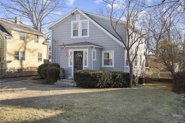 view of front of house with a front yard and central air condition unit