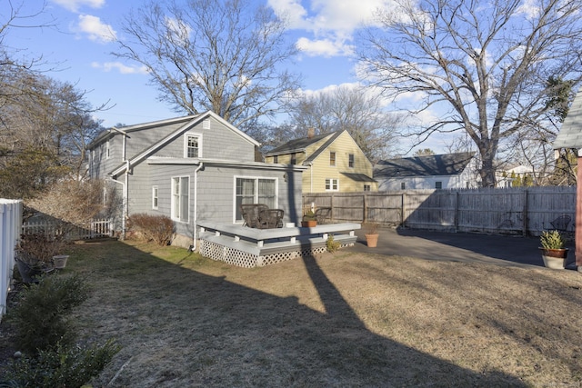 rear view of property featuring a wooden deck and a yard