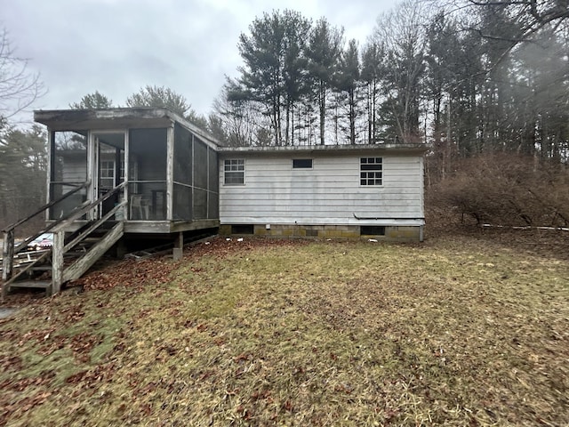 back of property with a sunroom and a yard