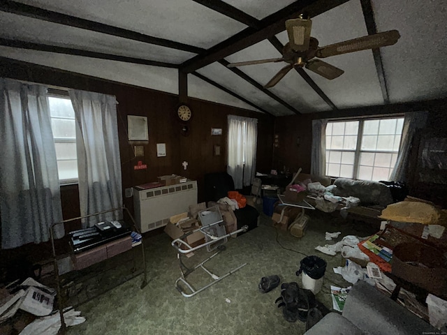 unfurnished living room with vaulted ceiling, wooden walls, and ceiling fan