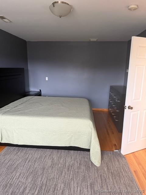 unfurnished bedroom featuring hardwood / wood-style floors and a fireplace