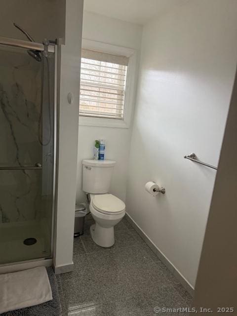 bathroom featuring an enclosed shower and toilet