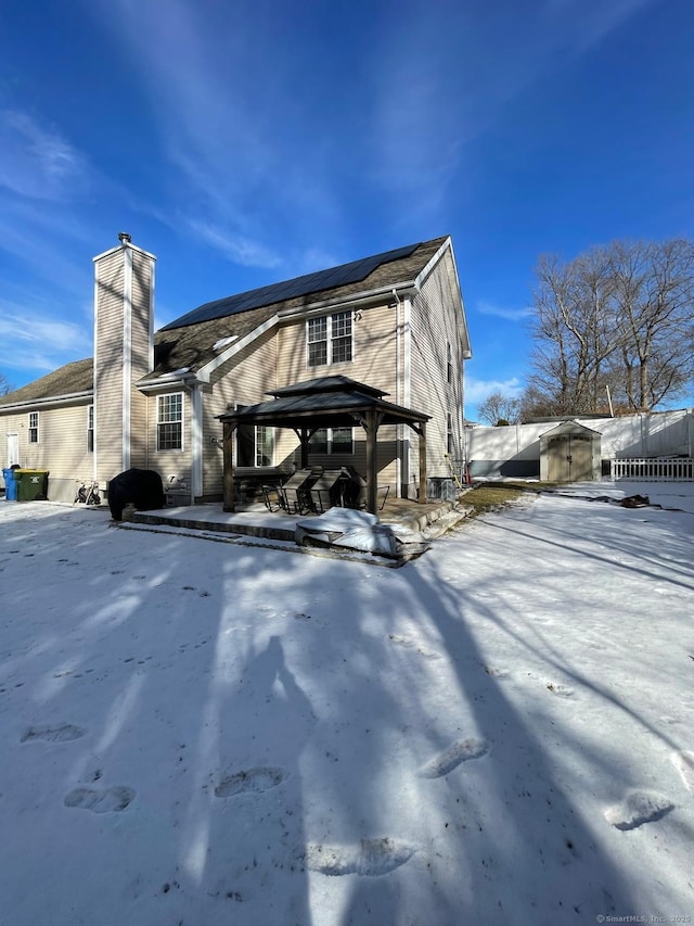 snow covered property featuring a gazebo and an outdoor structure