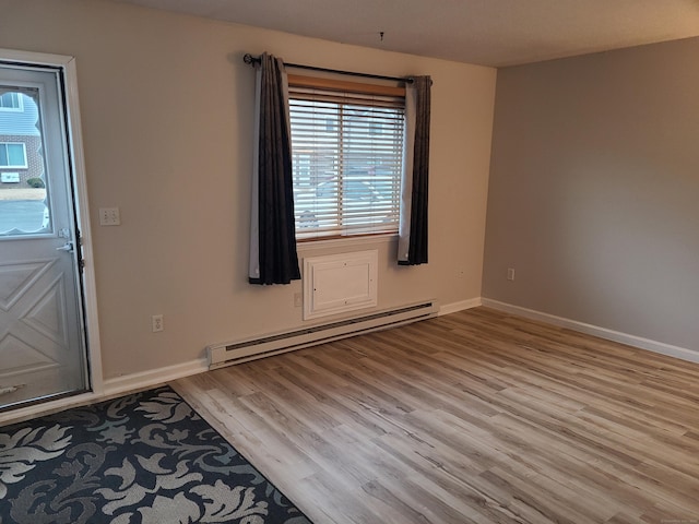 foyer entrance featuring a baseboard heating unit and light hardwood / wood-style flooring