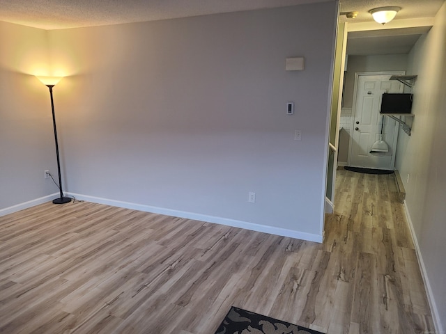 spare room featuring a textured ceiling and light wood-type flooring