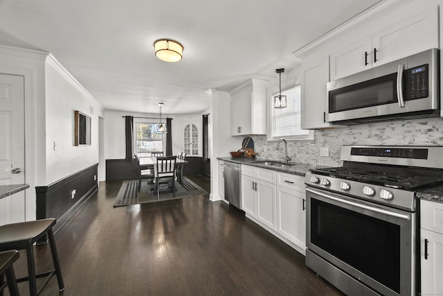 kitchen with stainless steel appliances, dark wood-style flooring, a sink, and white cabinets