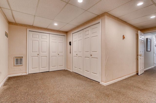 interior space featuring heating unit, a paneled ceiling, and carpet