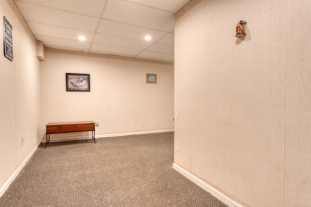 interior space featuring a paneled ceiling and carpet