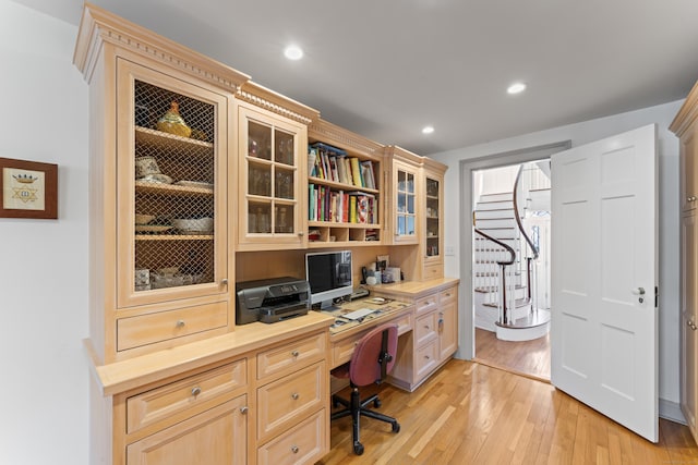 office space featuring light wood finished floors, built in study area, and recessed lighting