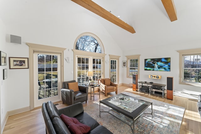 living area featuring baseboards, light wood-style flooring, a baseboard heating unit, high vaulted ceiling, and beam ceiling