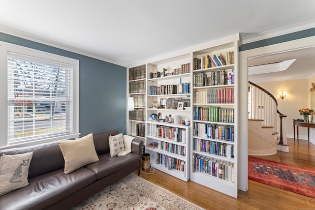 living area with stairs, ornamental molding, and wood finished floors