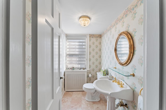 bathroom with radiator, wallpapered walls, and toilet