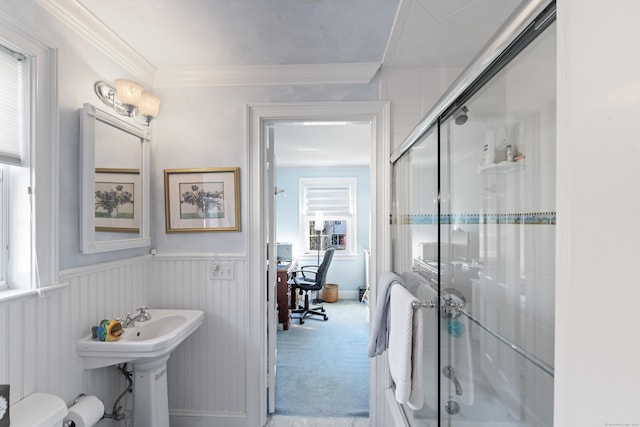 full bath with ornamental molding, a stall shower, wainscoting, and a sink