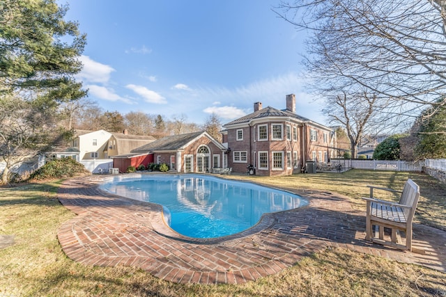 view of swimming pool featuring a patio area, a fenced in pool, fence, and a lawn