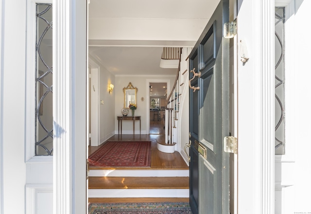 entrance foyer featuring stairs and baseboards