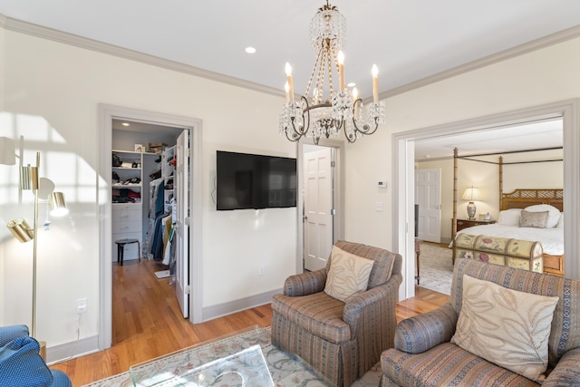 bedroom featuring light wood-type flooring, a spacious closet, ornamental molding, and a closet