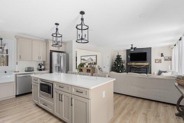 kitchen featuring pendant lighting, sink, a center island, light hardwood / wood-style floors, and stainless steel appliances