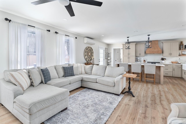 living room featuring ceiling fan, a wall mounted AC, and light wood-type flooring