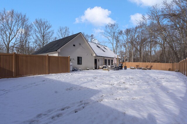 view of snow covered back of property