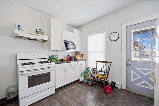 kitchen with white gas stove and white cabinets