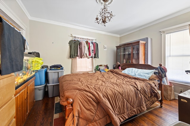 bedroom featuring dark hardwood / wood-style flooring, ornamental molding, and an inviting chandelier