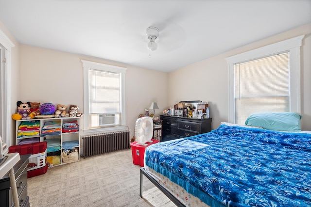 carpeted bedroom featuring cooling unit, ceiling fan, and radiator heating unit