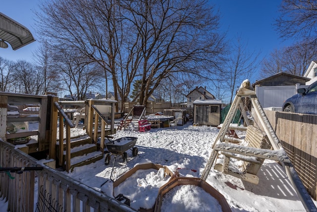 snow covered deck featuring a storage shed