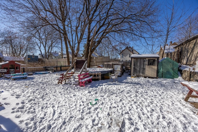 yard covered in snow with a shed