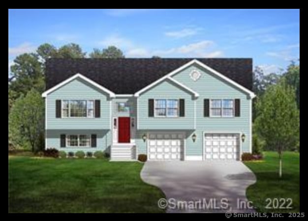 bi-level home featuring a garage and a front lawn