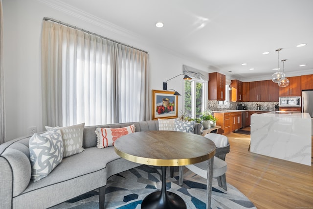 dining area featuring ornamental molding and light hardwood / wood-style flooring