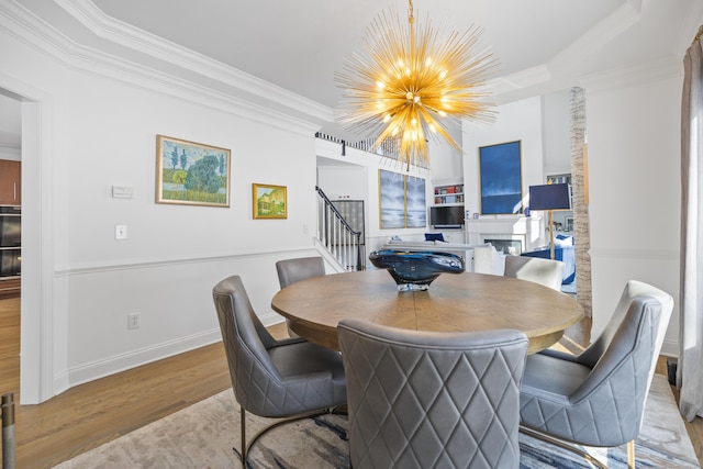 dining area featuring an inviting chandelier, crown molding, and light hardwood / wood-style flooring