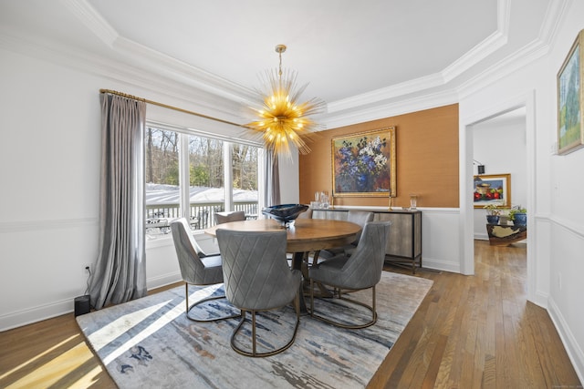 dining space featuring hardwood / wood-style flooring, crown molding, and a chandelier