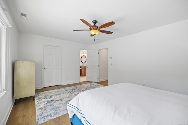 bedroom with ensuite bath, wood-type flooring, and ceiling fan