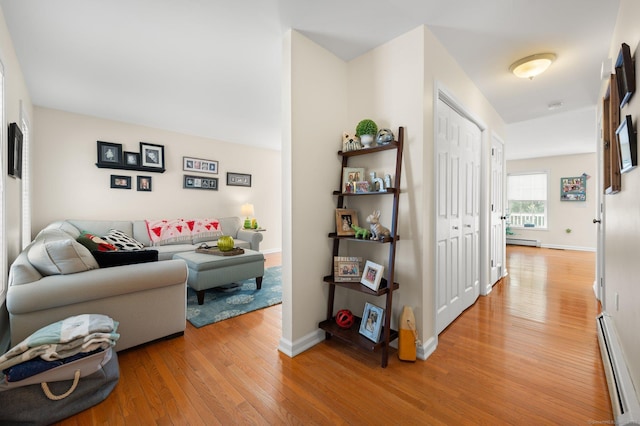 living room with a baseboard heating unit and hardwood / wood-style flooring