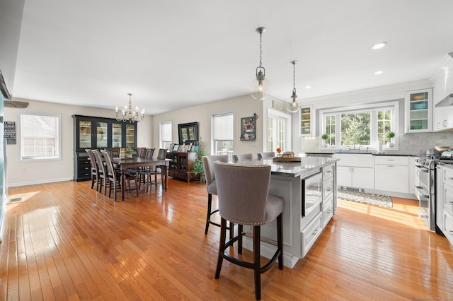 kitchen featuring pendant lighting, white cabinetry, a kitchen breakfast bar, range with two ovens, and a center island