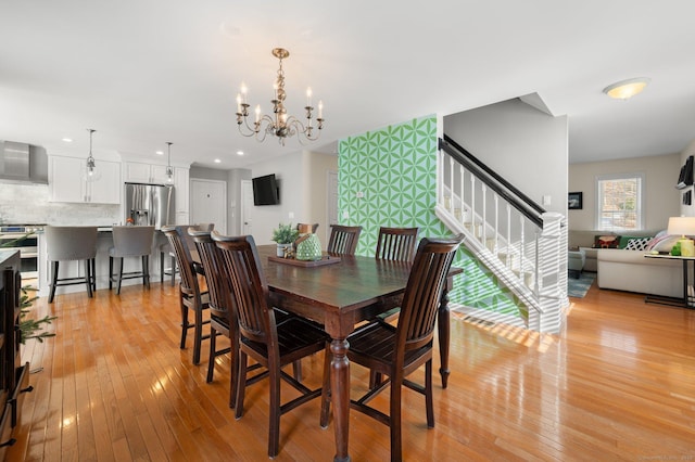 dining area with a chandelier and light hardwood / wood-style flooring