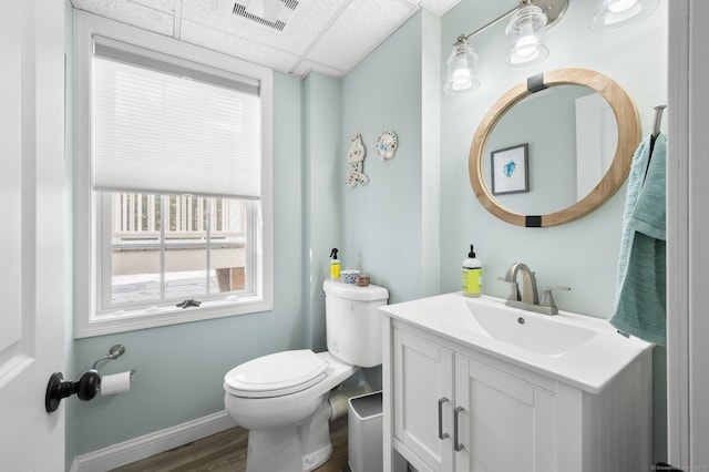 bathroom with vanity, hardwood / wood-style floors, a paneled ceiling, and toilet