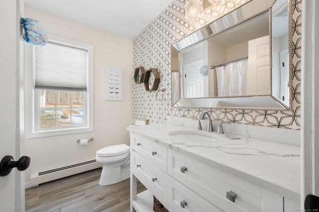 bathroom with baseboard heating, vanity, toilet, and hardwood / wood-style flooring