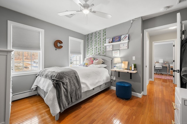 bedroom featuring light hardwood / wood-style flooring, a baseboard radiator, and ceiling fan