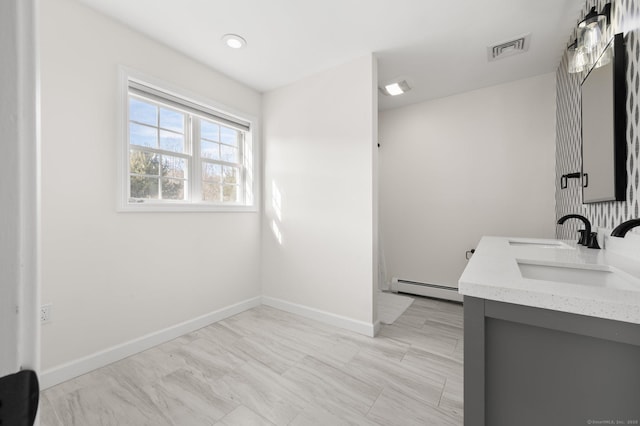 bathroom featuring baseboard heating and vanity